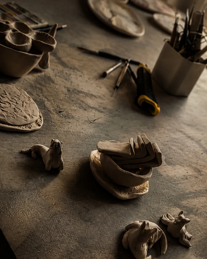 The studio worktable with clay tools and figures in progress